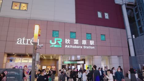 Tokyo-Electric-Town,-Akihabara,-night-shot-at-train-station-as-people-walk-in-slow-motion