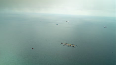 Floating-farm-and-sailing-vessel-near-Gibraltar,-view-from-above