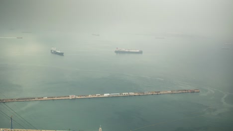 Moored-vessel-near-Gibraltar-harbor-on-thick-foggy-day,-time-lapse-view