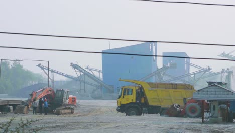 Pan-shot-of-a-Stone-Mine-Factory-with-crusher-machinery-trucks-and-buldozers-in-India