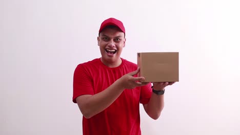 Wow-expression-of-Asian-young-courier-standing-while-holding-cardboard-box