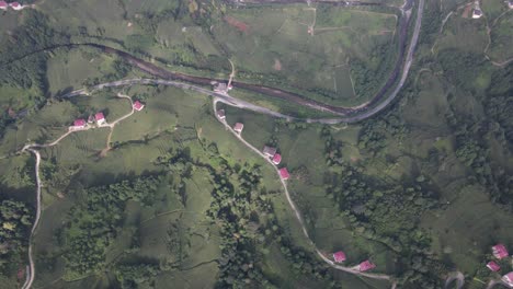 Drone-view-of-the-access-roads-to-the-houses-built-on-the-hill,-the-settlement-among-the-greenery