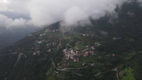 Drone-view-of-mountainside-town-on-a-cloudy-and-foggy-day,-Trabzon,-Turkey