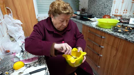 Grandma-mixing-ingredients-in-bowl-for-sauce,-sitting-in-the-kitchen
