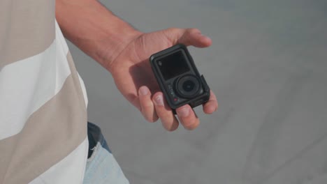 Man-pull-out-action-camera-from-pocket-and-put-it-on-stunt-scooter-handle-bar
