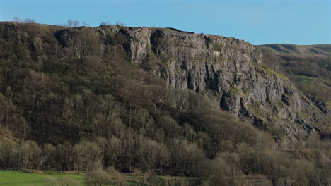 Establishing-Drone-Shot-of-Steep-Cliff-Rock-Face-and-Trees-Yorkshire