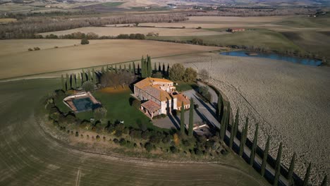 Drone-pullback-orbit-from-mansion-on-top-of-hill-overlooking-Val-d'Orcia-Tuscany-countryside