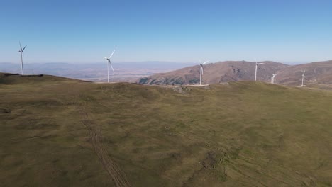 Vista-Por-Drones-De-Turbinas-Eólicas-Instaladas-En-Terreno-Montañoso,-Generación-De-Energía-Ecológica