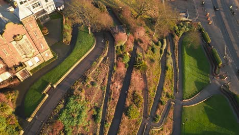 Aerial-top-down-shot-of-thin-curved-paths-in-front-of-a-castle-during-a-sunny-day-in-Scarborough,-England