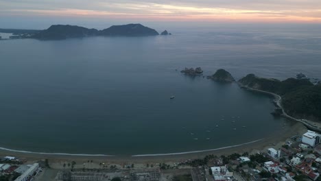 Aerial-shot-Blue-landscape-blue-bay,-calm-waters,-sunset-Mexican-coast-Barra-de-Navidad