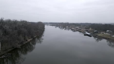 Flying-over-river-through-hazy-sky,-aerial-drone