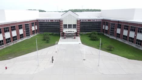 Entrance-of-Anchor-Bay-High-School,-aerial-drone-fly-toward-view