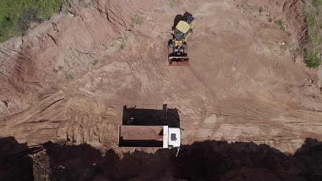 A-drone-shot-of-a-digger-loading-into-a-truck-on-a-property-development