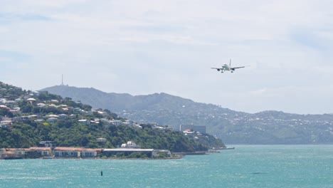 An-Air-New-Zealand-Airbus-A320-landing-at-Wellington-airport,-approaching-from-the-harbor-in-New-Zealand