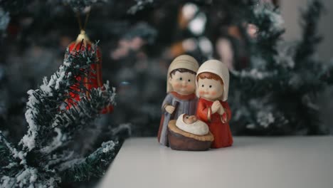 Nativity-figurines-with-festive-tree-backdrop---close-up-zoom-out