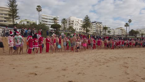Rot-Gekleidete-Menschen-Warten-Auf-Den-Beginn-Des-Weihnachtsschwimmens-Im-Meer