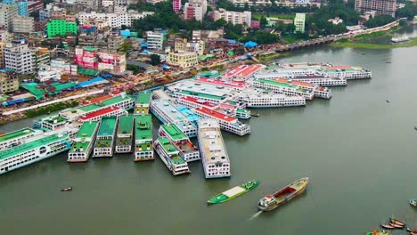 Vista-Aérea-De-Un-Concurrido-Muelle-A-Lo-Largo-Del-Río-Buriganga-Con-Muchos-Veleros-Atracados-En-El-Astillero-De-La-Ciudad-De-Keraniganj,-Dhaka,-Bangladesh