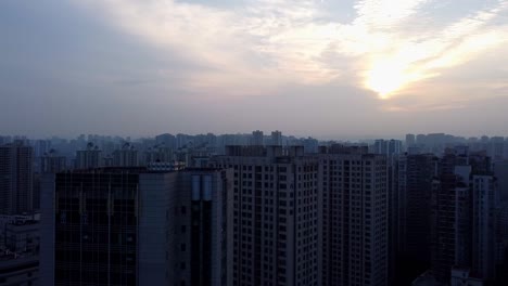Cinematic-aerial-ascent-reveals-the-City-Plaza,-skyscrapers,-and-breathtaking-sunset-sky-in-Chongqing,-China