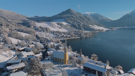 Paisaje-Invernal-De-Nieve-Blanca-En-El-Lago-Schliersee-Con-Montañas-Y-Agua-Azul-Oscuro