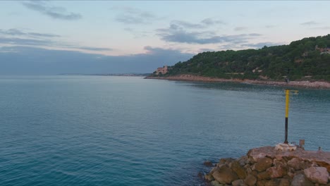 Drohne-Fängt-Touristen-Auf-Felsigem-Pier-Am-Roc-De-Sant-Gaieta,-Tarragona-Ein