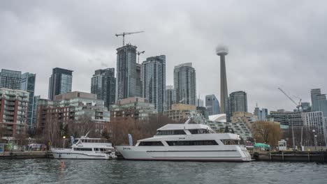 Construction-cranes,-skyscrapers-and-boats-in-cloudy-Toronto,-timelapse