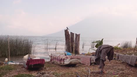 Wooden-fishing-boats-covered-with-blankets-on-shore-of-Lake-Atitlan,-Guatemala