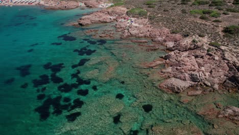 Seitliche-Dolly-Luftaufnahme-Der-Felsigen-Küste-Und-Schwimmender-Menschen-Auf-Der-Insel-Maddalena,-Sardinien,-Italien