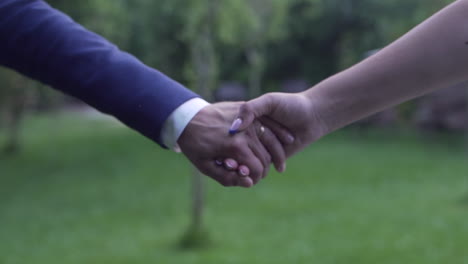 Couple-holding-hands,-symbolic-wedding-gesture