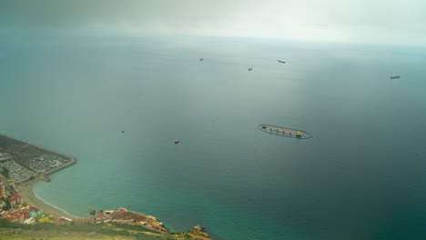 Floating-farm-and-industrial-port-of-Gibraltar-coast,-time-lapse-from-above