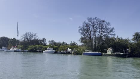 Various-Kelien-boats-are-moored-on-a-river-in-nature,-taken-in-good-weather-in-France
