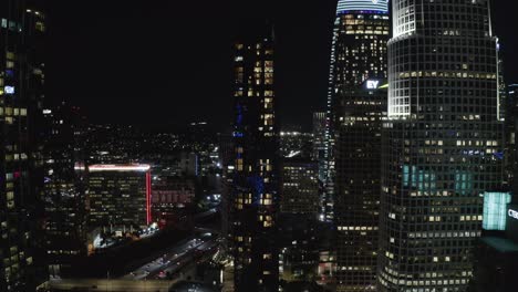 Luftaufnahme-Der-Innenstadt-Von-Los-Angeles-Bei-Nacht,-Verkehr-Und-Wolkenkratzer-In-Lichtern,-Kalifornien,-USA