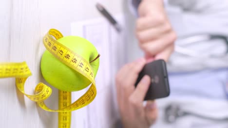 Vertical-video-of-Diet-appointment-with-nutritionist,-Apple-and-measuring-tape-on-the-table