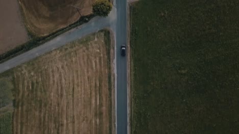 A-tracking-shot-of-a-car-driving-through-agricultural-land