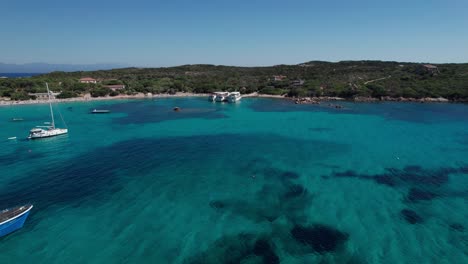 aerial-forward-shot-with-panoramic-view-of-coastline-and-anchored-boats-Maddalena-Island-Sardinia-Italy-during-day