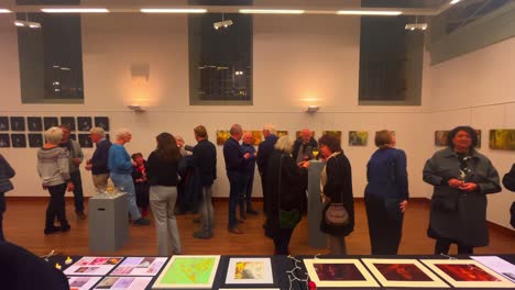 People-talking-and-networking-at-art-exhibition-with-paintings-and-photography