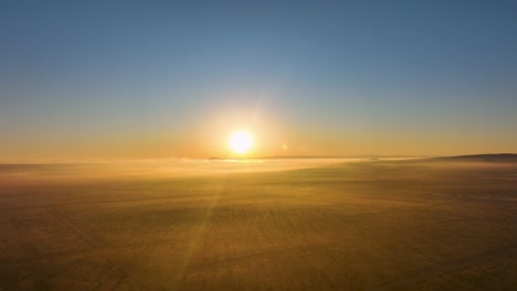 Goldener-Sonnenaufgang-über-Nebliger-Landschaft,-Lichtstrahlen,-Die-Durch-Dunst-Dringen,-Ruhige-Morgenstimmung
