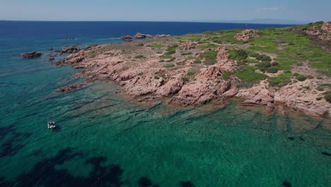 aerial-circle-pan-footage-on-rocky-seashore-of-Sardinia-Island-in-Italy-during-summertime