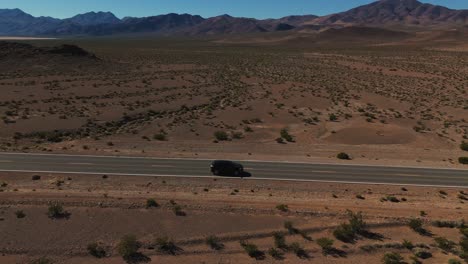 Car-driving-on-desert-highway-in-Nevada