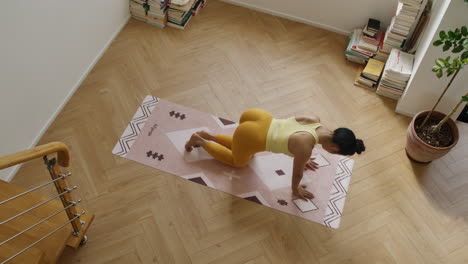 Frau-Praktiziert-Yoga-Übungen-In-Einer-Modernen-Wohnung,-Blick-Von-Oben-Auf-Ein-Fittes-Mädchen-Während-Des-Trainings