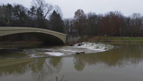 Berea,-Ohio-Metroparks-pan-shot-of-small-waterfall-and-pedestrian-bridge