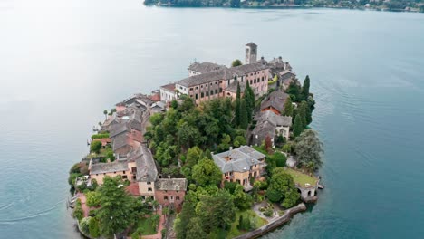 Isola-di-San-Giulio-on-Lake-Orta,-Italy,-with-historic-buildings-and-lush-greenery,-aerial-view