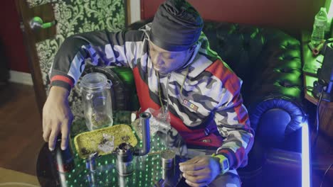 a-black-man-disassembles-an-electronic-water-bong-stir-the-unburned-marijuana