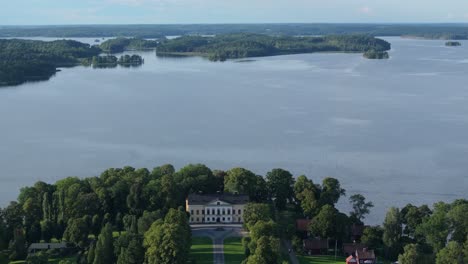 Forward-sky-high-drone-over-Taxinge-castle-toward-lake-in-Sweden