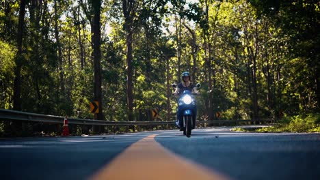Cinematic-slow-motion-travelling-on-moped-through-beautiful-forest-in-Asia