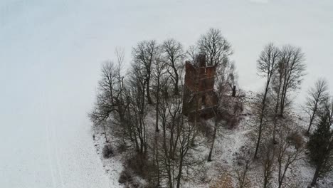Aerial-circle-shot-above-old-abandoned-church-bell-tower-remains-during-winter