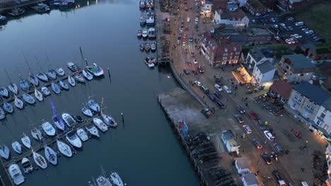 Forward-drone-shot-of-beautiful-Scarborough-Harbour-with-boats-parked-beside-a-busy-street-and-a-beach-in-Scarborough,-England