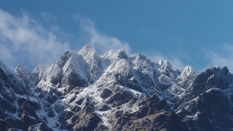 Zeitraffer-Schroffer,-Schneebedeckter-Berge-Mit-Wunderschönen-Wolken,-Die-über-Einen-Blauen-Himmel-Rollen