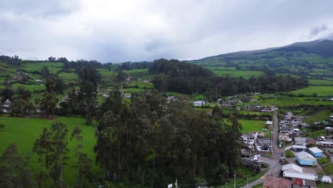 Distant-storm-clouds-gather-over-green-Andean-farm-landscape-Ecuador-DRONE