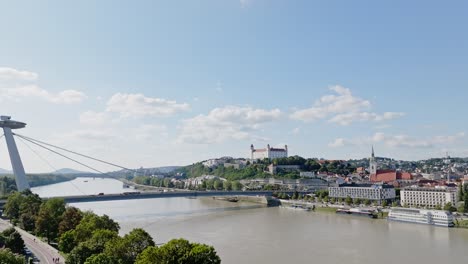 Aerial-drone-view-of-Bratislava-Castle-on-a-hill-with-SNP-bridge-and-UFO-restaurant-on-Danube-river-on-beautiful-summer-sunny-day