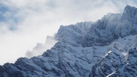 Schroffe,-Schneebedeckte-Berge-Mit-Wunderschönen-Wolken,-Die-über-Einen-Blauen-Himmel-Rollen